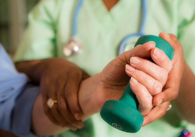 Physical therapist helping a woman do exercises after wrist surgery